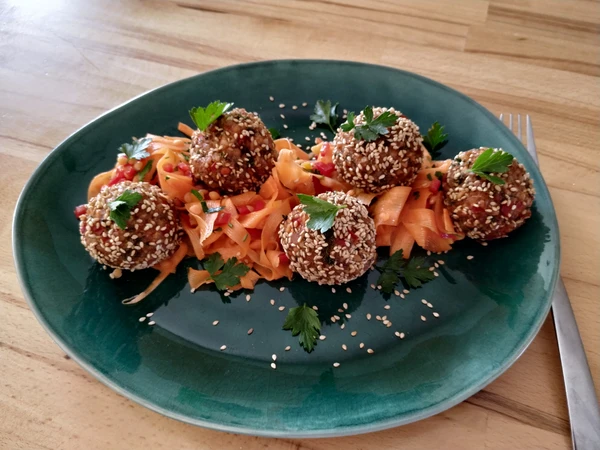 Das Ergebnis: Curry-Linsen-Bällchen auf einem Salat aus dünnen Karotten-Streifen.