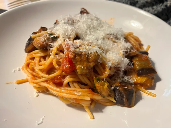 Fertig zum Servieren: Pasta alla Norma mit etwas Käse bestreut.